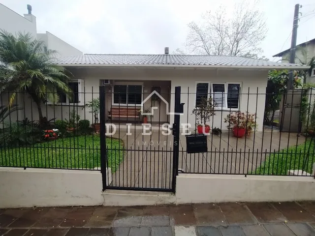 Fachada de uma casa em Lajeado, Brasil com cerca e portão de ferro preta.