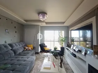 Sala de estar com sofá grande e vista para o exterior.