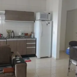 Foto de uma cozinha com armários e eletrodomésticos brancos.