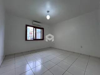 Ambiente interno de uma sala com piso de cerâmica clara e janela.