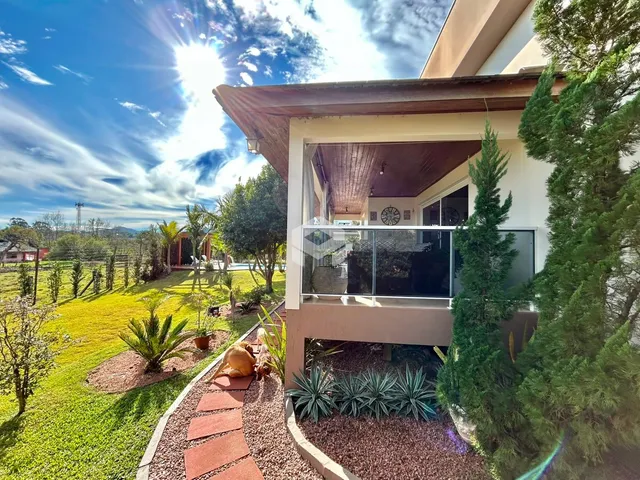 Vista da fachada de uma residência com jardim e varanda em Lajeado, Brasil.