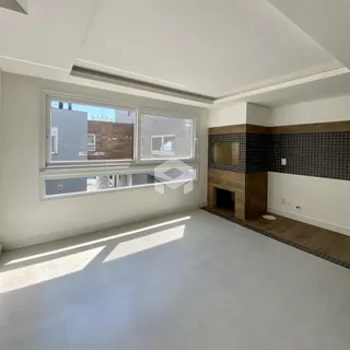 Sala de estar com grandes janelas e lareira em um imóvel no Brasil.