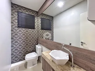 Foto de um banheiro com revestimento de parede e bancada de granito.