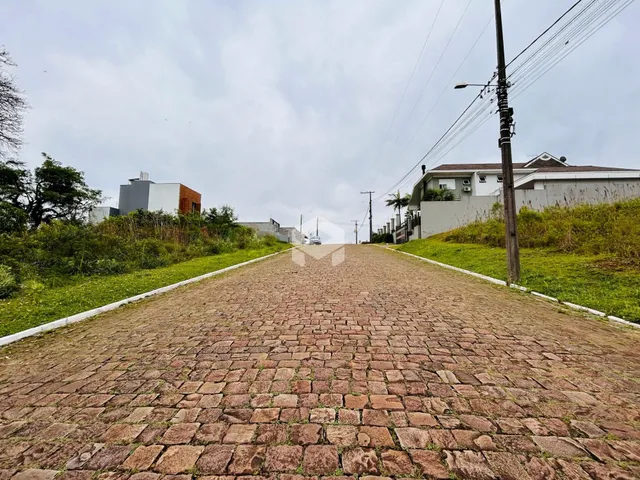 Vista de uma rua pavimentada em Lajeado, Brasil, com casas ao fundo.