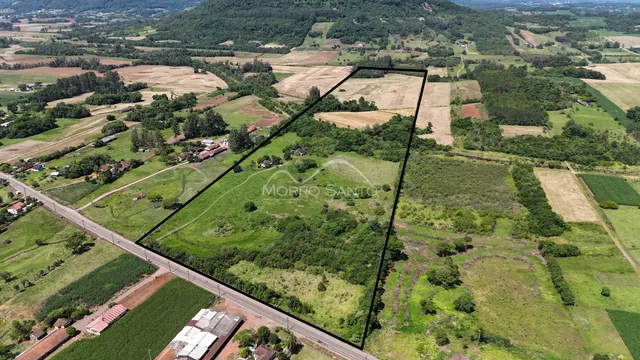 Vista aérea de uma propriedade rural com campos e vegetação.