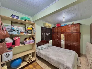 Quarto com armário de madeira e estantes em um imóvel no Brasil.