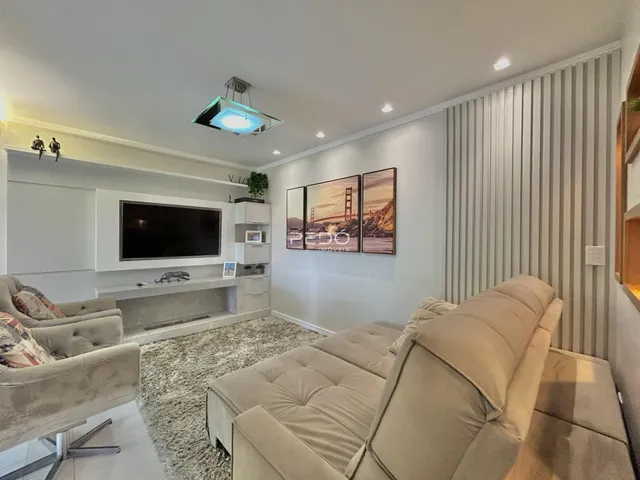 Sala de estar moderna com sofá e painel de parede em um imóvel no Brasil.