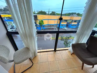 Vista da janela de uma propriedade em Lajeado, Brasil, mostrando uma rua molhada.