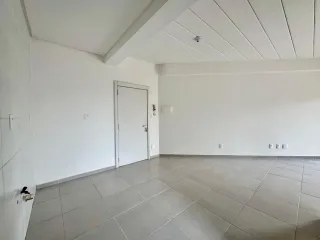 Sala ampla com piso de cerâmica e paredes brancas.