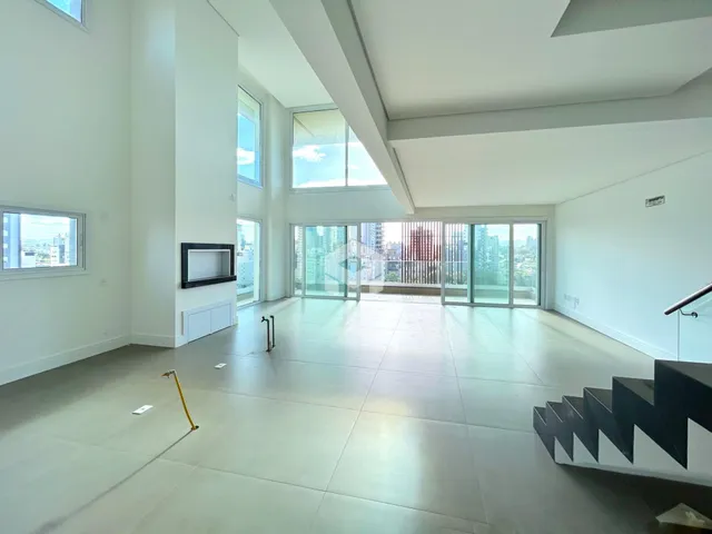 Ambiente amplo com piso claro e grandes janelas de vidro em um imóvel em Lajeado.