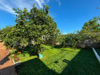 Vista do jardim com gramado verde e árvores em Lajeado, Brasil.