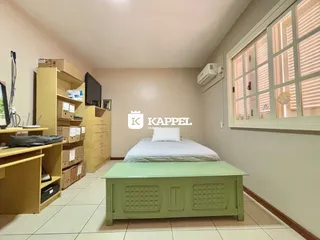 Foto de um quarto com cama e estantes de madeira.