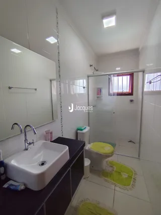 Foto de um banheiro interno com pia e box de vidro.