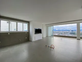 Sala ampla com grandes janelas que proporciona uma vista panorâmica da paisagem urbana.