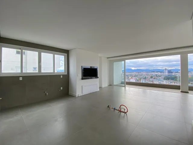 Sala ampla com grandes janelas que proporciona uma vista panorâmica da paisagem urbana.