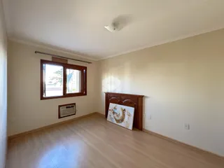 Sala de estar com piso de madeira clara e janela.
