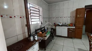 Foto interna de uma cozinha com bancada e janela em um imóvel.