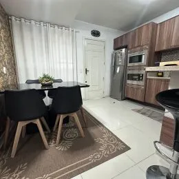 Sala de estar com cortinas brancas e piso claro.