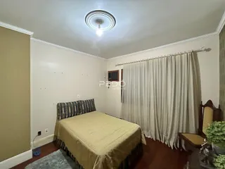 Quarto com cama e cortinas em uma residência.