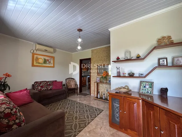 Sala de estar com sofá e piso de madeira em um imóvel no Brasil.