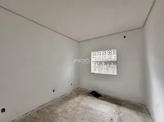 Foto de um cômodo vazio com paredes brancas e piso de concreto.