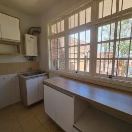 Ambiente interno com grandes janelas e piso de cerâmica.