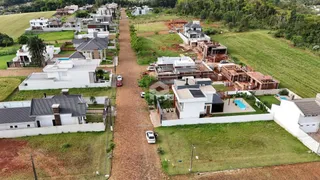 Vista aérea de um loteamento residencial com casas e áreas de terra em Lajeado.