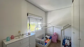 Foto de um quarto claro com cama e móveis brancos.