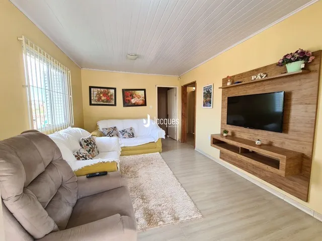 Sala de estar com sofá e piso claro em um imóvel no Brasil.