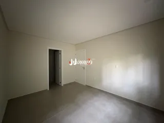 Uma foto de um ambiente interno vazio com paredes brancas.