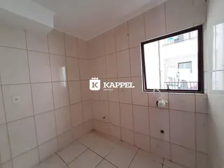 Foto de um cômodo interno com piso e paredes revestidos em azulejos brancos.