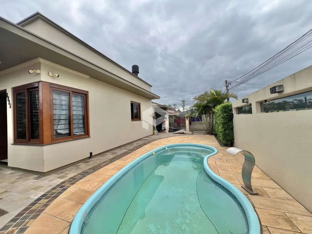 Fachada de casa com piscina no quintal.