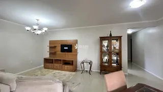 Sala de estar com móveis de madeira e sofá claro.
