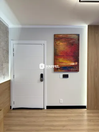 Uma sala de estar com piso de madeira e uma pintura na parede.