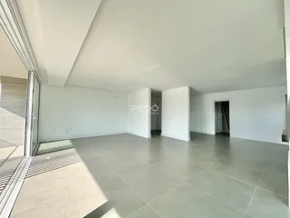 Ambiente interno de uma sala ampla com piso de cerâmica clara.