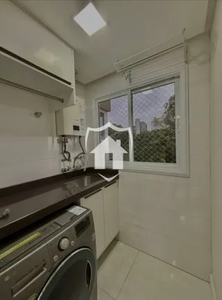 Foto de uma área de serviço com bancada e máquina de lavar em um imóvel.