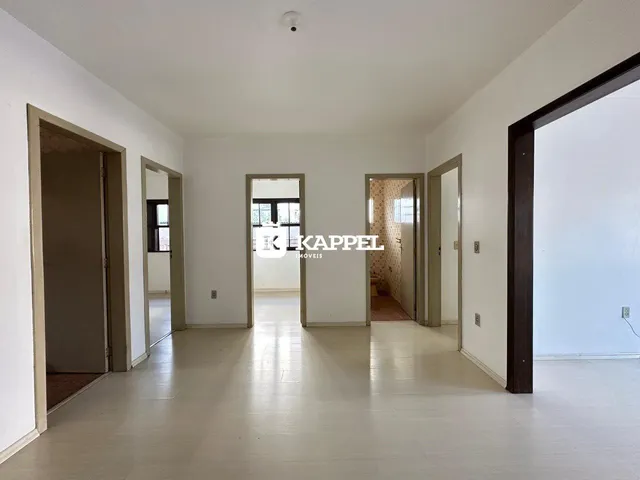 Hall de entrada com paredes brancas e piso claro, mostrando a profundidade do ambiente.