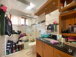 Foto de um banheiro com revestimento cerâmico e janela.