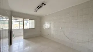 Interior de um ambiente com paredes e piso revestidos de cerâmica.