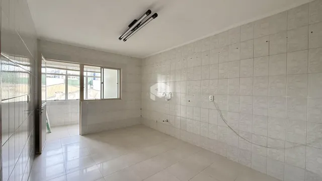 Interior de um ambiente com paredes e piso revestidos de cerâmica.