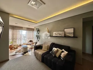 Sala de estar com sofá e vista para o exterior em Lajeado.