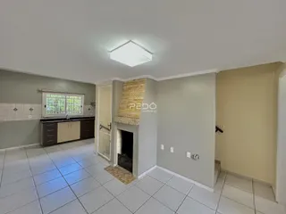 Foto do interior de uma sala com piso de cerâmica e lareira.