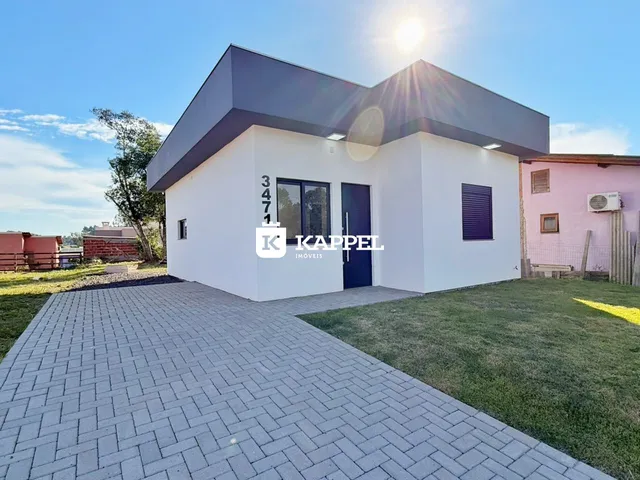 Foto da fachada de uma casa moderna branca com telhado escuro em Lajeado, Brasil.