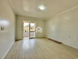 Ambiente interno de uma sala com piso de madeira clara.