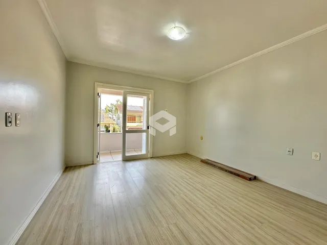 Ambiente interno de uma sala com piso de madeira clara.