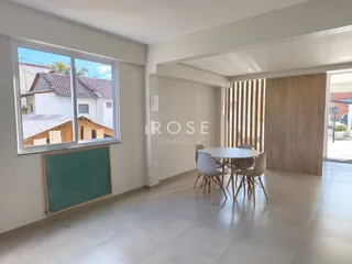 Ambiente interno de uma sala com piso de cerâmica e uma mesa redonda.