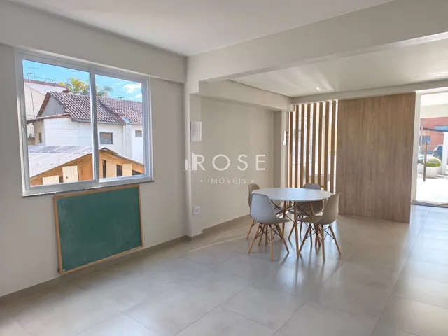 Ambiente interno de uma sala com piso de cerâmica e uma mesa redonda.