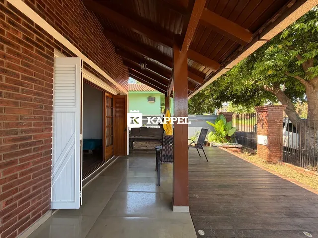 Vista de uma área externa coberta com piso de madeira e deck.