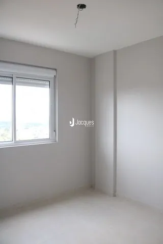 Vista interna de um cômodo com parede branca e janela.