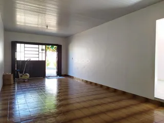 Ambiente interno de uma sala com piso de cerâmica e parede branca.